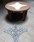 struttura in legno di un tavolino con vicino il mosaico realizzato da montare al suo interno